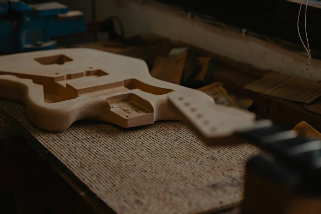 Caja de guitarra acústica sin terminar sobre un banco de trabajo de luthier